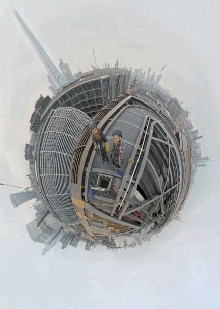 Two workers inspect metal cladding framework atop a high-rise building in a 360-degree tiny planet cityscape view